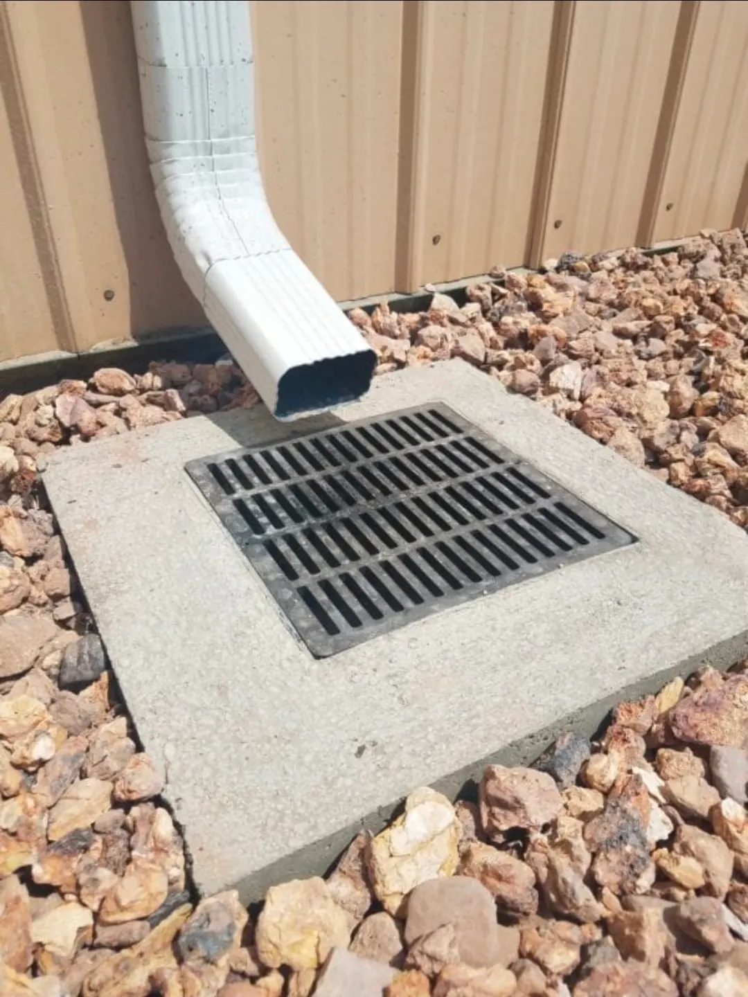 Concrete-framed catch basin surrounded by river rock