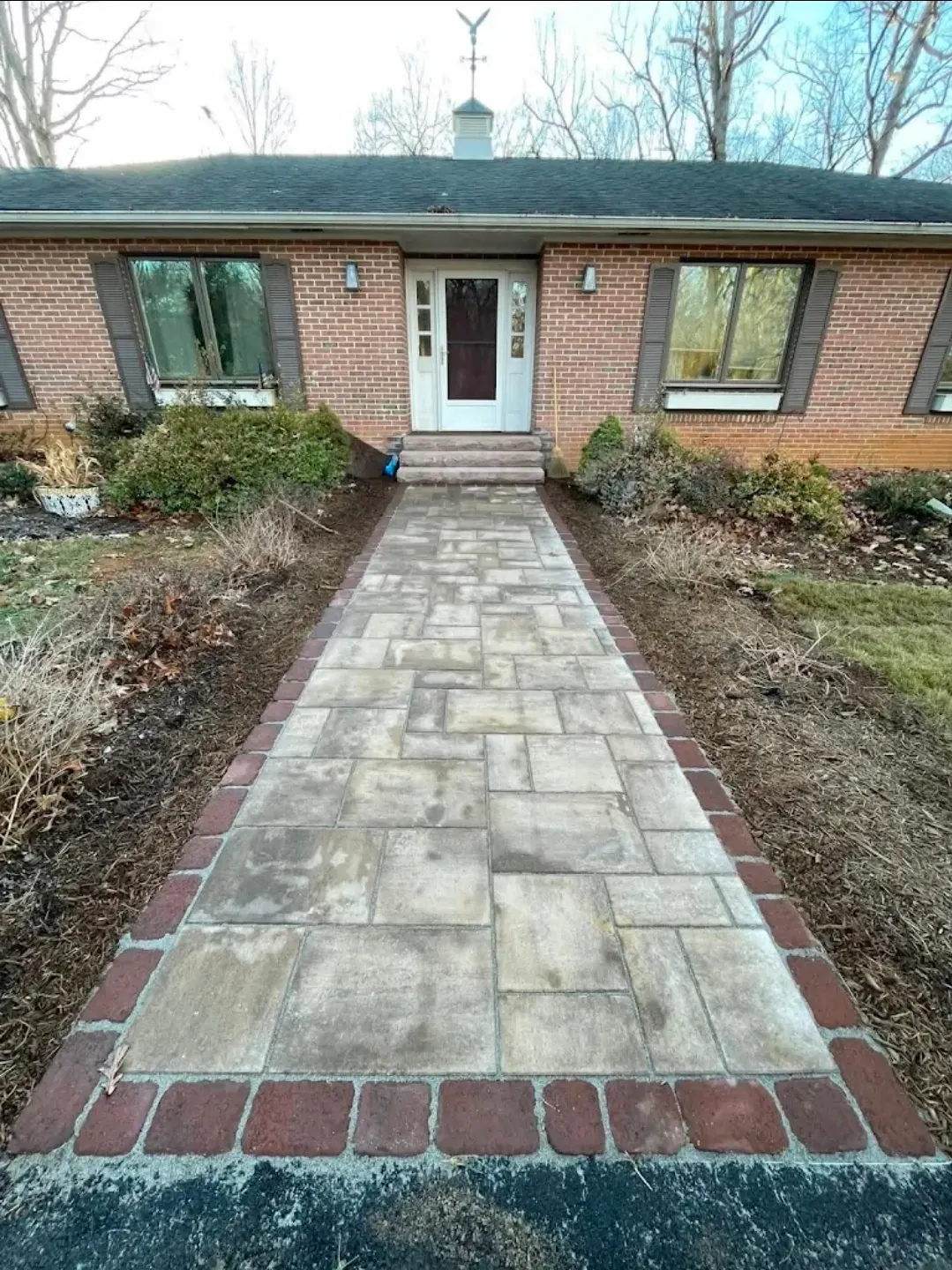 Custom paver walkway with brick border leading to home entrance - HT Outdoor Living Freeport FL