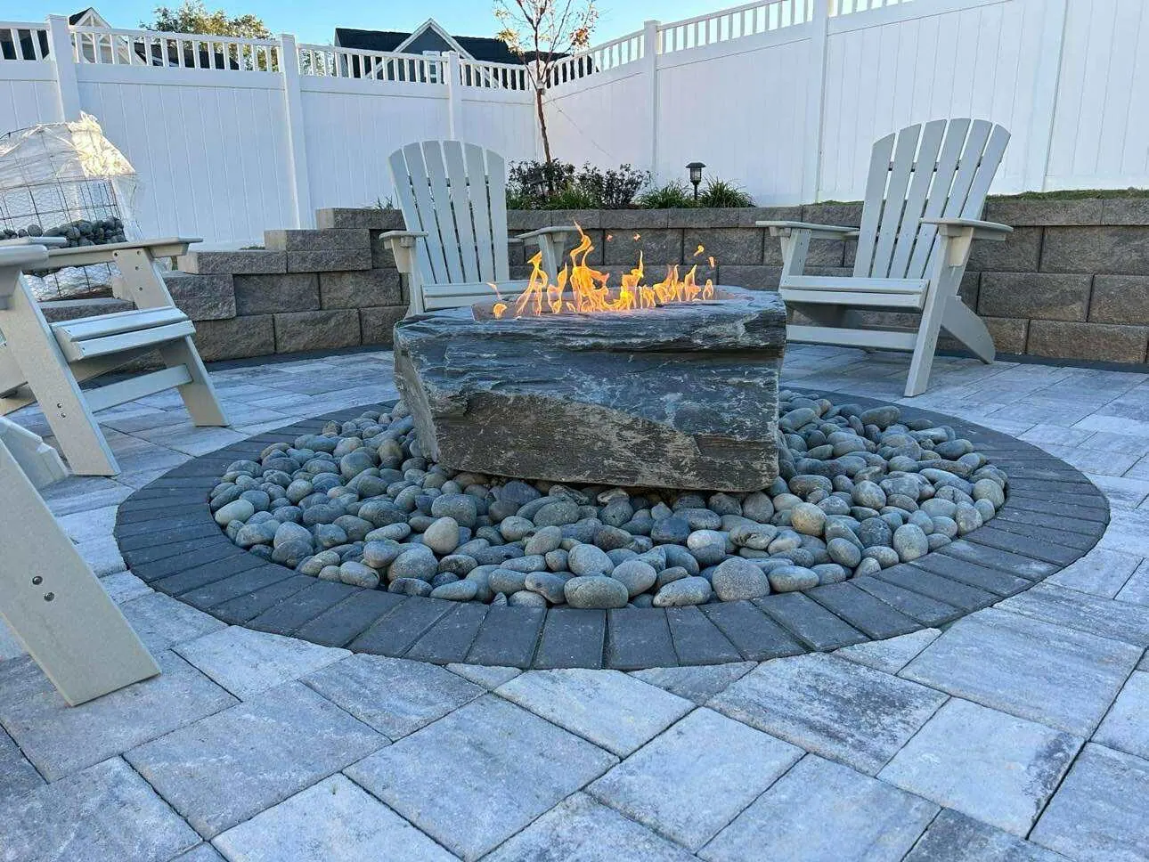 Natural stone fire pit on paver patio with seating area - Hardscaping Freeport FL
