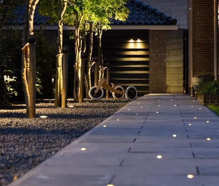 Modern paver walkway with embedded LED ground lights at night
