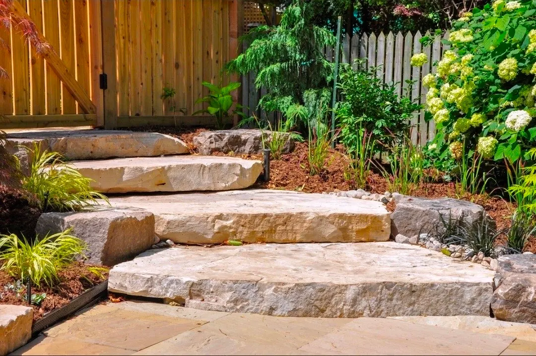 Natural stone steps with hydrangeas, ornamental grasses, and mulch beds