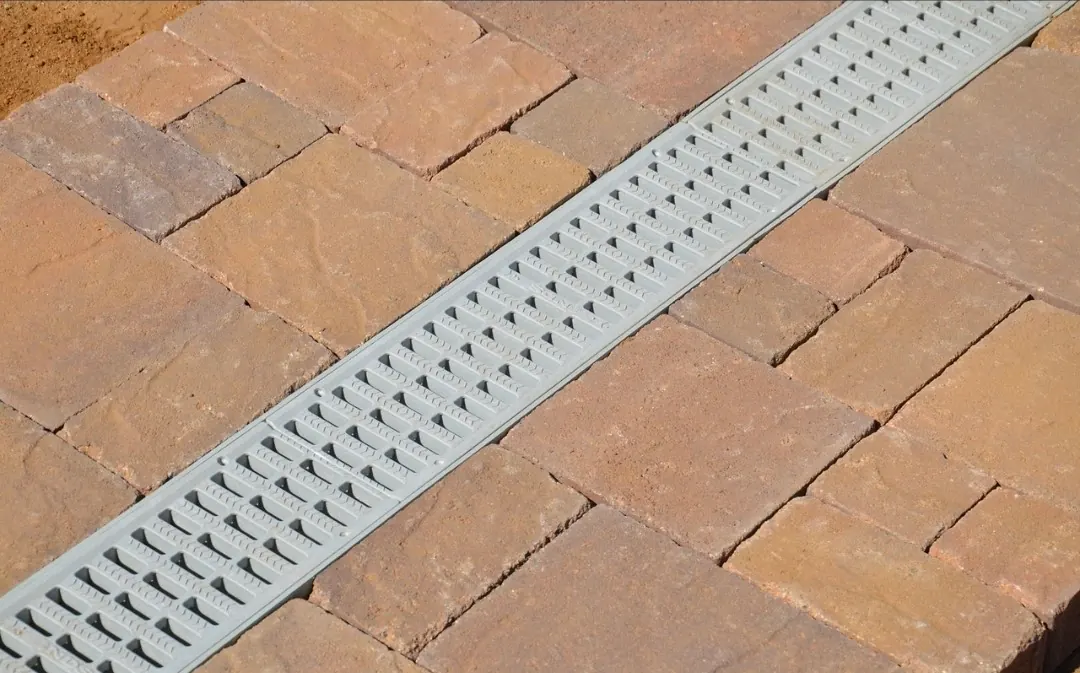 Linear channel drain integrated into paver patio