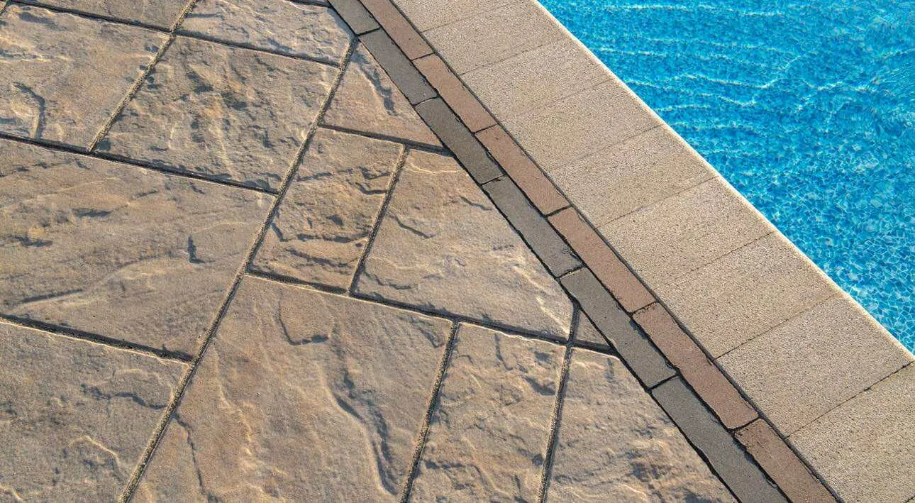 Premium tan paver pool deck with coping edge