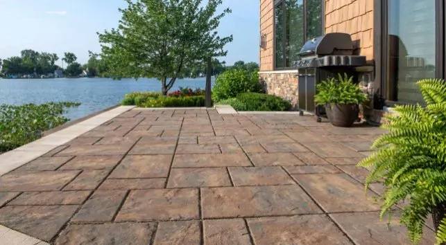 Waterfront paver patio with outdoor grill station and lake view - Hardscaping Destin FL